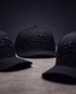 Three black baseball caps with embroidered &